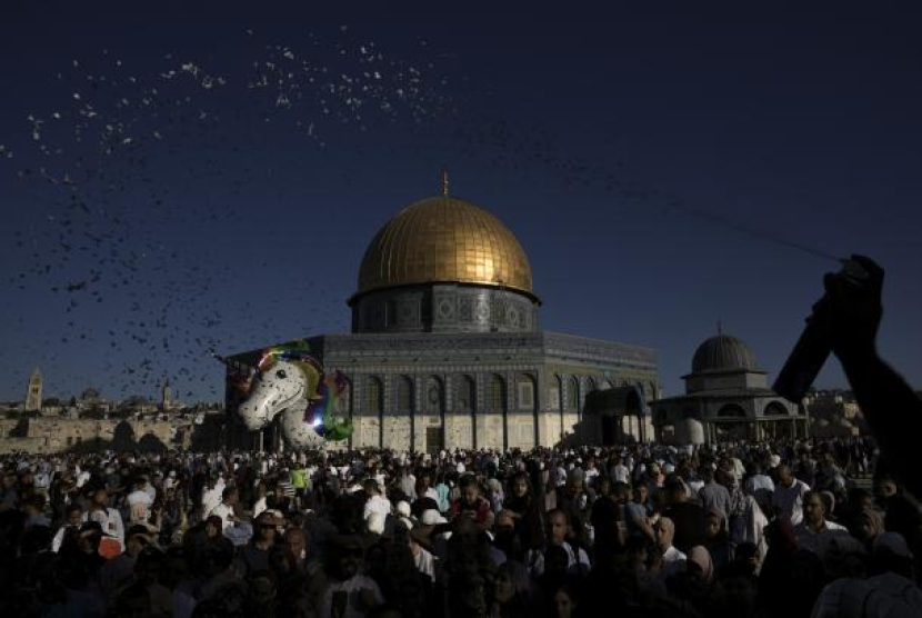  Warga Palestina merayakan hari pertama Idul Adha di samping kuil Dome of the Rock di kompleks Masjid Al Aqsa di Kota Tua Yerusalem, Sabtu, 9 Juli 2022. Foto: AP/Mahmoud Illean