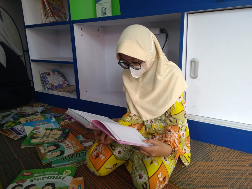 Seorang anak sedang membaca buku di Pojok Baca Tjimanoek, Ahad (15/5/2022). (Lilis Sri Handayani)