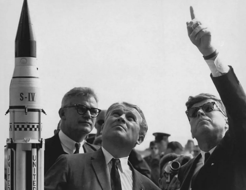 Dr Wernher von Braun (tengah) menjelaskan Sistem Peluncuran Saturnus kepada Presiden John F Kennedy (kanan). Wakil Administrator NASA Robert Seamans berdiri di sebelah kiri von Braun. Gambar: NASA