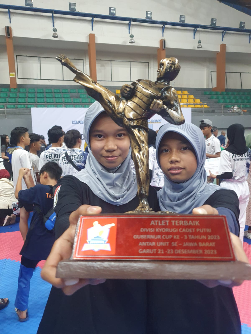 Gita (kiri) dengan piala atlet taekwondo terbaik Gubernur Cup Jawa Barat.