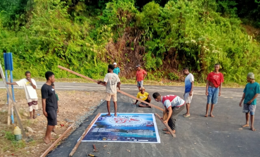 Para pemuda suku Moi di Malaumkarta Raya, Kabupaten Sorong, menyiapkan baligo Festival Egek di pintu masuk Kampung Malaumkarta, Ahad (4/6/2023). Senin (5/6/2023), bertepatan dengan Hari Lingkungan Hidup, masyarakat adat Moi mengadakan Festival Egek (foto: panitia festival egek).