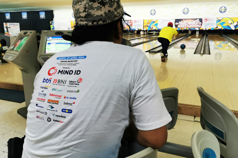 Seorang peserta 14th Fun Bowling Tournament 2024 memperhatikan lemparan dilakukan lawannya di Grand Bowling Serpong, Sabtu (26/4/2024) 