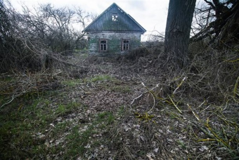 Sebuah rumah yang ditinggalkan penghuninya di Karpylivka, Ukraina, Kamis, 7 April 2016. Karpylivka adalah salah satu desa terdekat dengan reaktor pembangkit nuklir Chernobyl yang meledak. Foto: AP Photo/Mstyslav Chernov