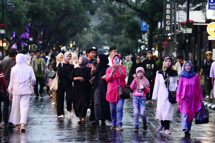 Warga berjalan kaki di tengah jalan menikmati suasana Jalan Braga di sela pelaksanaan Braga Bebas Kendaraan (Braga Beken) di Jalan Braga Panjang, Sabtu (4/5/2024). (Foto Yogi Ardhi/Republika Network)