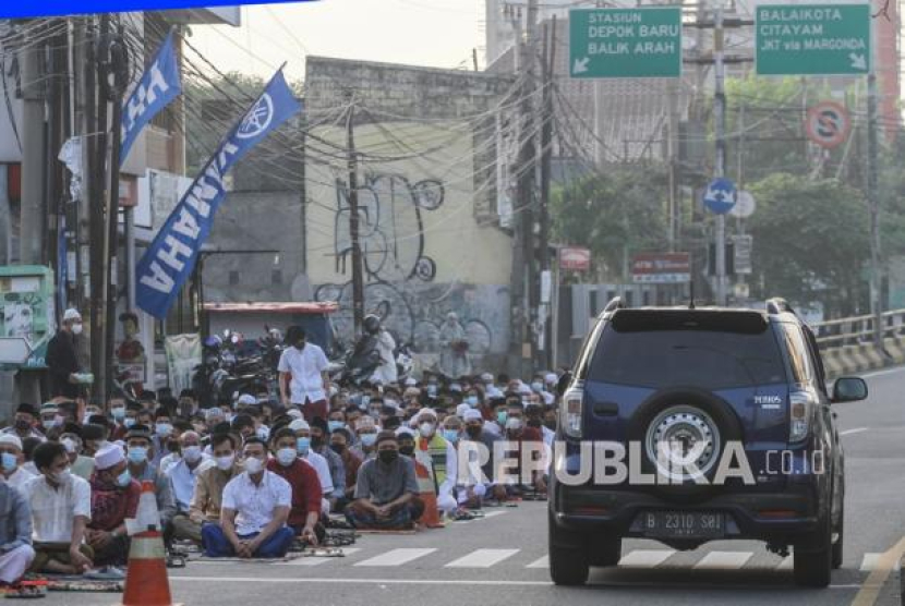 Sejumlah umat muslim mendengarkan ceramah usai shalat Idul Fitri 1442 H di Jalan Arif Rahman Hakim, Depok, Jawa Barat, Kamis (13/5/2021). Foto: Antara/Asprilla Dwi Adha