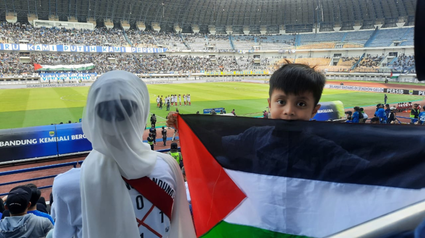 Salah seorang bobotoh cilik mengibarkan bendera Palestina