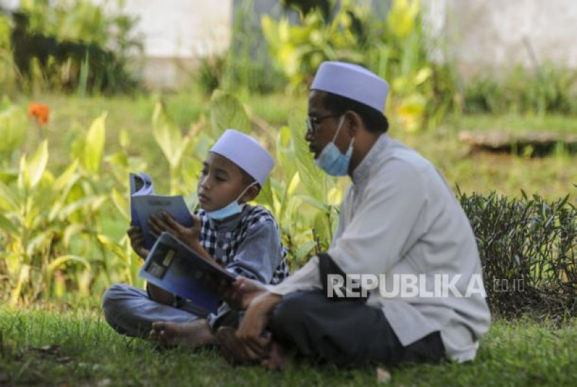 Sejumlah umat Islam membaca Al-Quran sambil menunggu waktu berbuka puasa di depan Masjid Raya Jakarta Islamic Center, Jakarta, Senin (18/4/2022). Foto: Republika/Putra M. Akbar