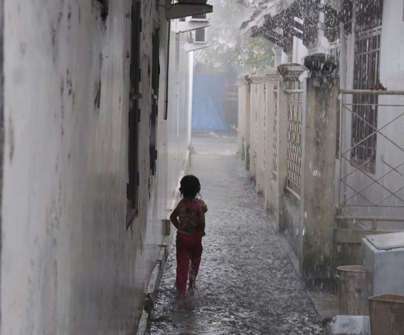 Seorang anak bermain hujan-hujanan. (Lilis Sri Handayani)