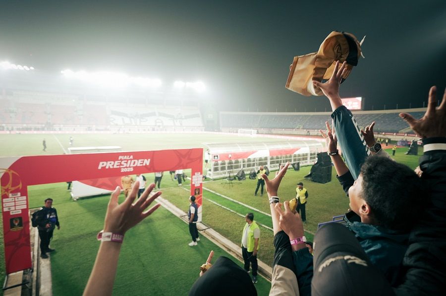 Suporter menyambut jersey Oxford United yang dilemparkan pemain ke tribune Stadion Si Jalak Harupat, Bandung, dalam pelaksanaan Piala Presiden 2025, Juli 2025. (Yogie Gandanaya/Skor.id)