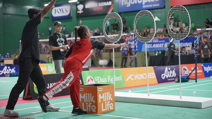 Tantangan Throwing The Shuttlecock melempar kok ke dalam lubang target.