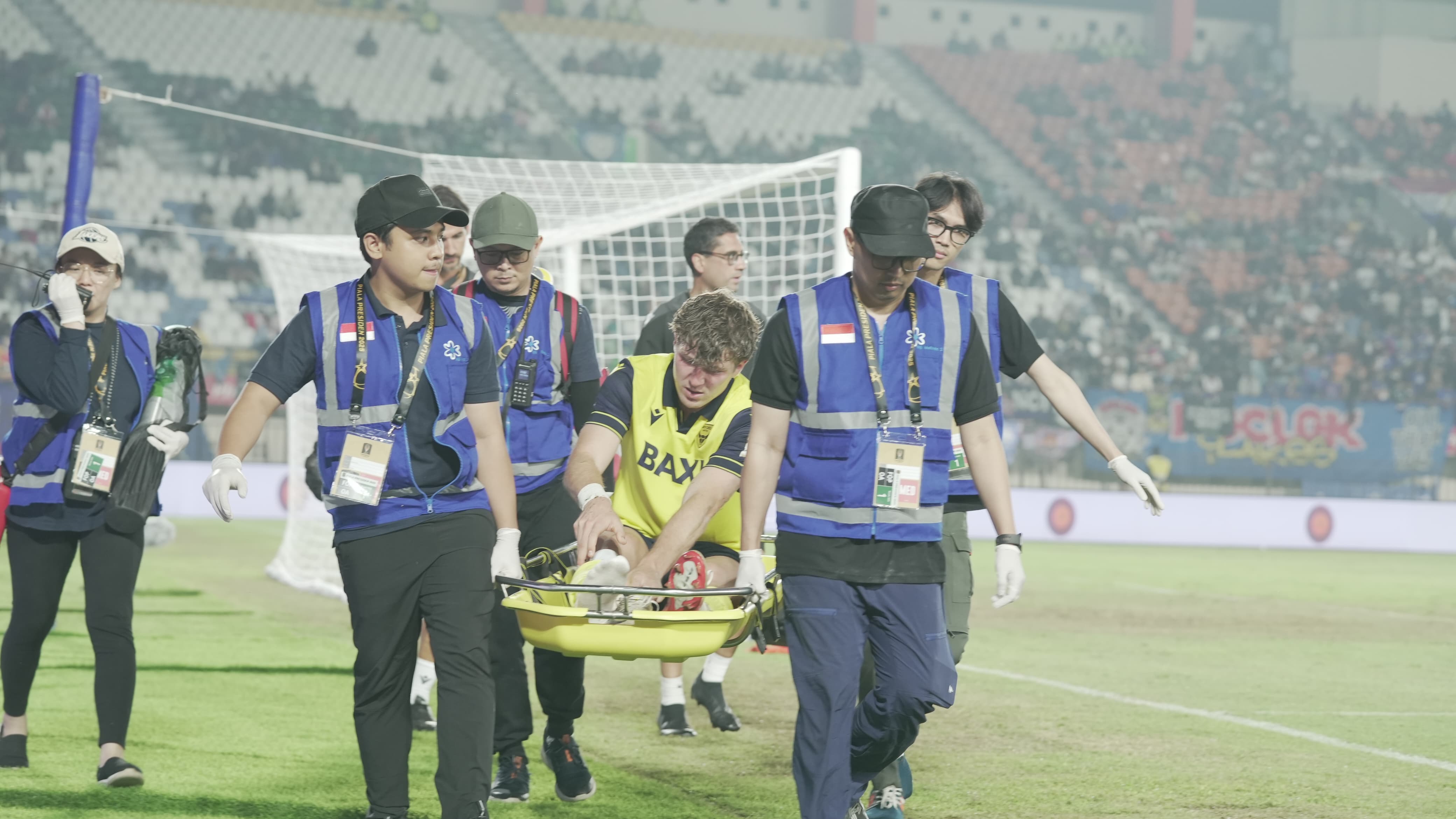 Penyerang Timnas Indonesia, Ole Romeny, ditandu karena mengalami masalah pada kakinya saat membela Oxford United melawan Arema FC pada Piala Presiden 2025 di Stadion Si Jalak Harupat, Bandung, 10 Juli 2025. (Yogie Gandanaya/Skor.id)