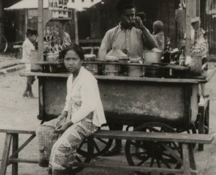 Pedagang es limun di kawasan kaki lima di jalanan Tanah Abang di Batavia di masa lalu. Pedagang ini mengokupasi trotoar yang sebenarnya hak pejalan kaki.