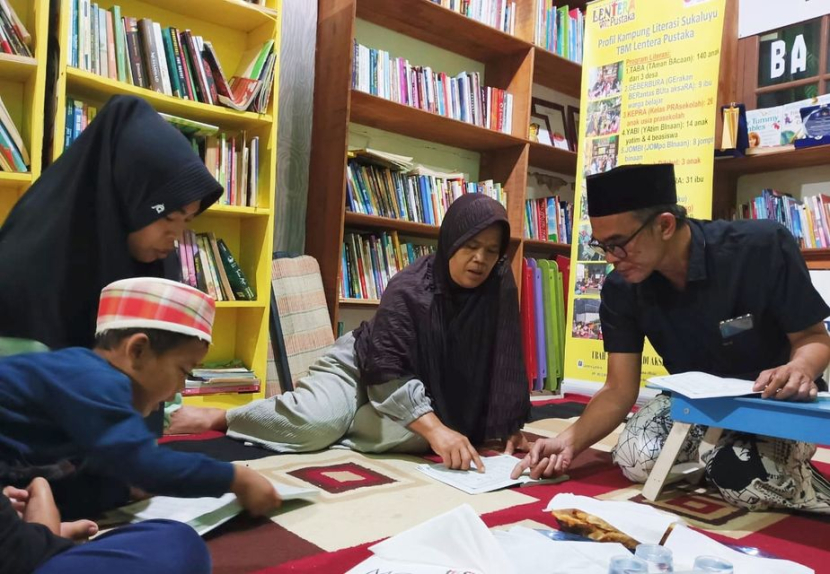 Pendiri TBM Lentera Pustaka Syarifudin Yunus (kanan), saat mengajar buta aksara Alquran di TBM Lentera Pustaka, Bogor, Sabtu (5/11/2022) malam.  (Foto: Dok TBM Lentera Pustaka)
