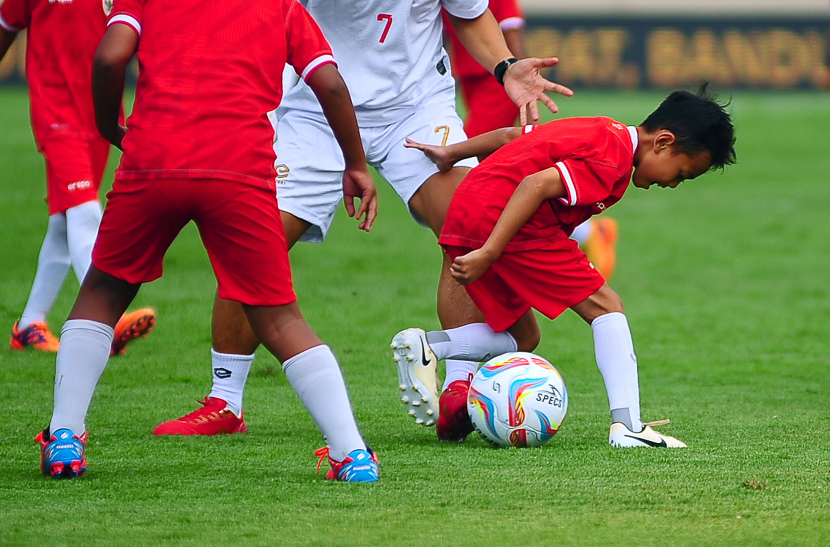 Siswa SSB menggocek bola pada laga funsoccer jelang pembukaan Turnamen Piala Presiden 2024 di Stadion Si Jalak Harupat, Kabupaten Bandung, Jumat (19/7/2024). (FOTO: YOGI ARDHI/REPUBLIKA NETWORK) Nikon D3, Nikkor 300/2.8 ED MF.