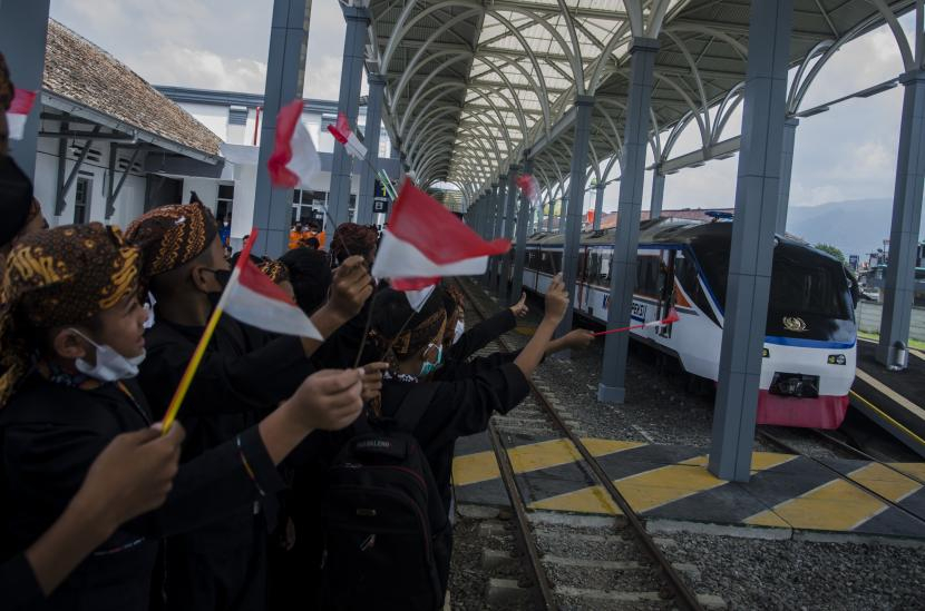 Para pelajar mengibarkan bendera Merah Putih saat kereta api inspeksi melintasi jalur rel di Stasiun Garut, Garut, Jawa Barat, Kamis (24/3/2022). (ANTARA/Novrian Arbi/Republika.co.id)