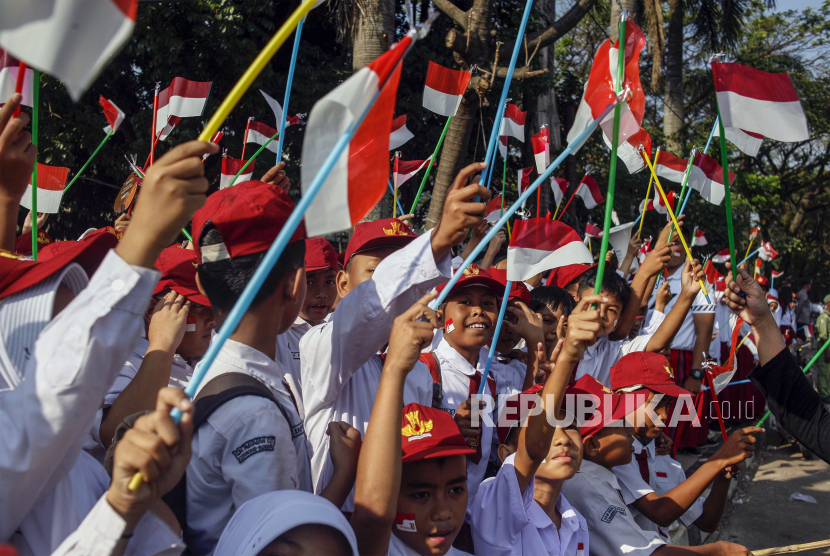 Para siswa sekolah dasar mengibar-kibarkan ben dera Merah Putih kecil, menyambut perayaan Hari Proklamasi Kemerdekaan di Cibinong. Menjelang Sumpah Pemuda 1928, ada Pandu yang memasang bendera Merah Putih kecil di sepeda, dipukuli polisi (foto: antara/republika).