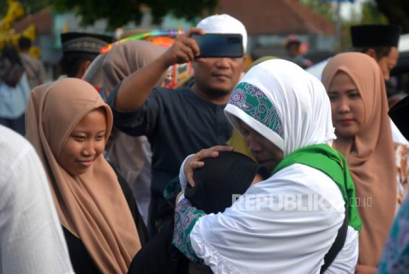 Jamaah calon haji kloter 48 mencium cucunya sebelum pemberangkatan menuju Embarkasi Solo di Pendopo Parasamya Bantul, Yogyakarta, Rabu (7/6/2023). Foto: Republika/Wihdan Hidayat