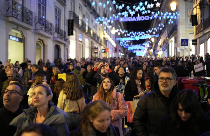 Orang-orang saat merayakan malam natal pekan lalu di Lisbon Chiado. Dok: AP/Armando Franca