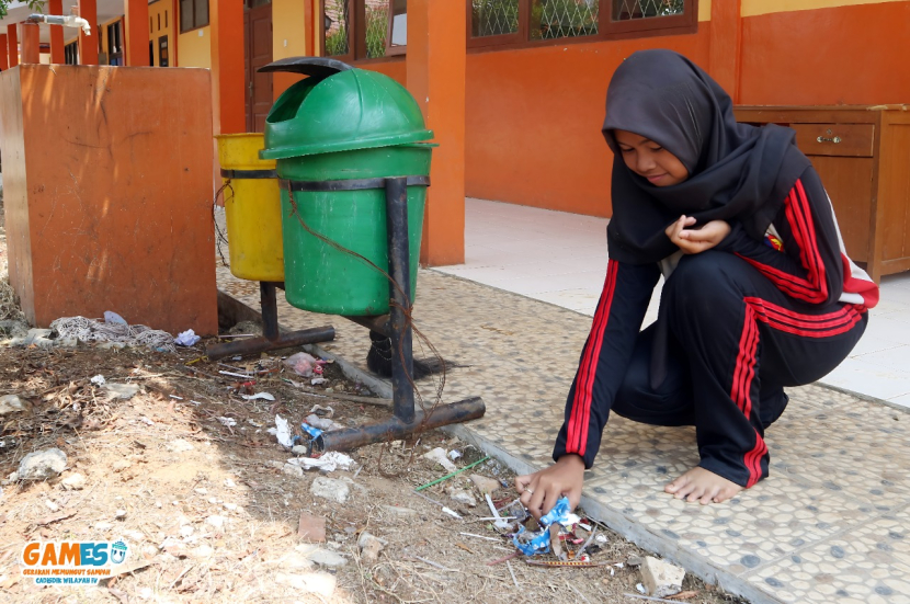 Seorang Siswa SMK sedang memungut sampah