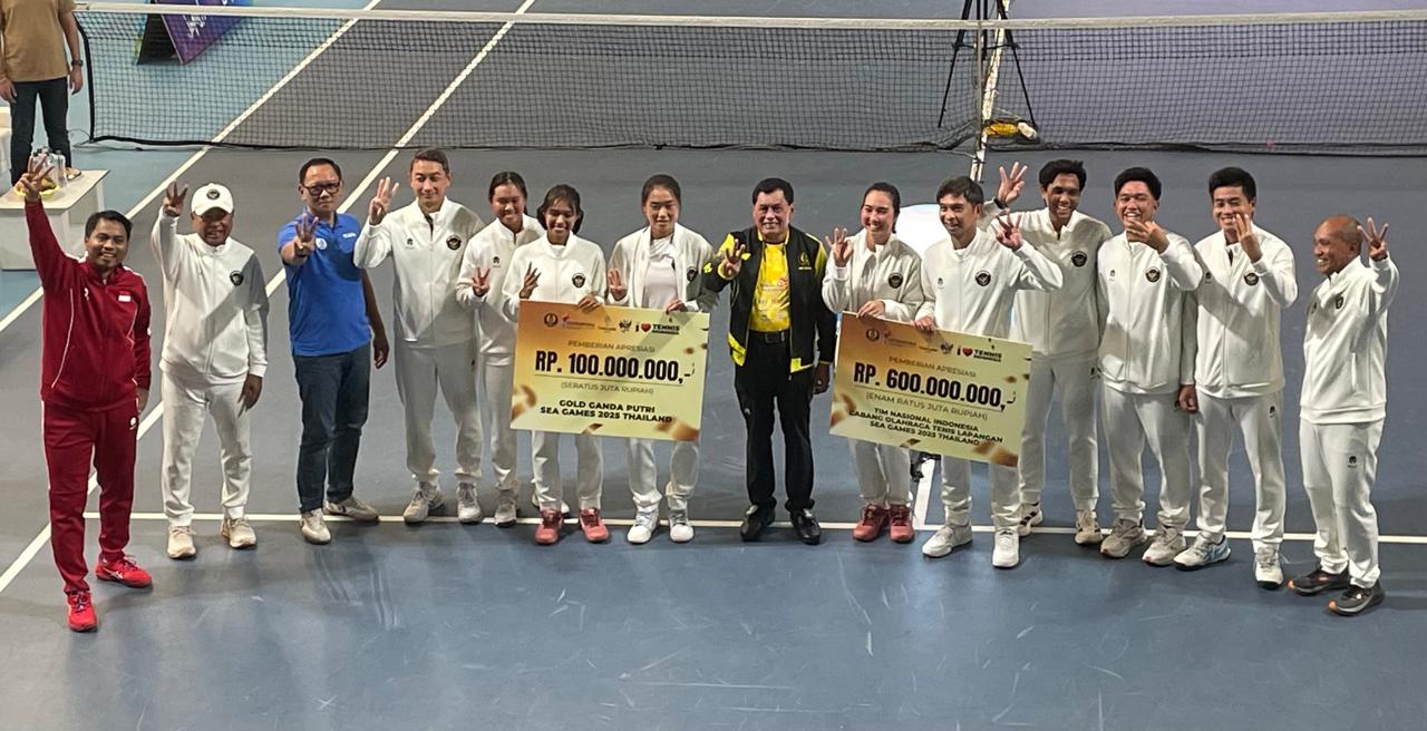Ketua Umum PP Pelti, Nurdin Halid (pakaian kuning), memberikan bonus kepada Timnas tenis Indonesia yang berprestasi di SEA Games 2025 Thailand pada 23 Desember 2025. (Taufani Rahmanda/Skor.id)