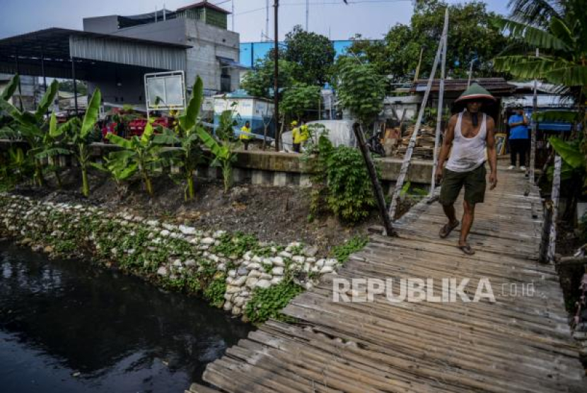 Warga melintasi jembatan yang tidak layak di Jalan Swadaya, Kebon Jeruk, Jakarta, Jumat (11/6/2021). Dari Kebon Pala Hingga Pulo Gebang, Cerita di Balik Nama Tempat Betawi. Foto: Republika/Putra M. Akbar