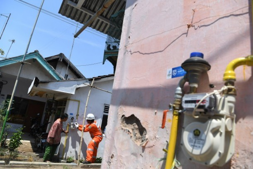 Petugas memberikan penjelasan terkait meteran gas kepada warga di salah satu rumah warga pengguna jaringan gas bumi PGN. Foto: Republika.