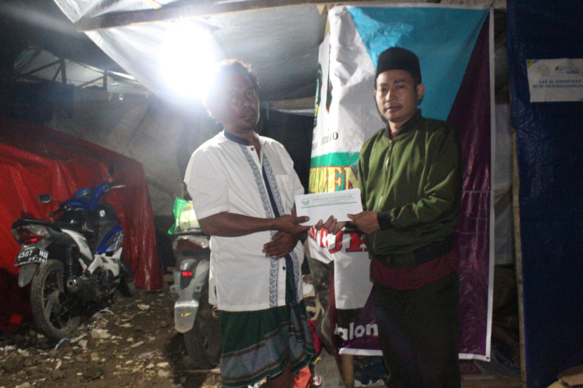 Wakil Dekan Bidang Kemahasiswaan FAI UIKA Bogor, Yono, MHI menyerahkan bantuan kepada warga yang tertimpa gempa di Desa Nagrak, Kabupaten Cianjur, Jawa Barat, Selasa (29/11/22) malam. Foto : dok  