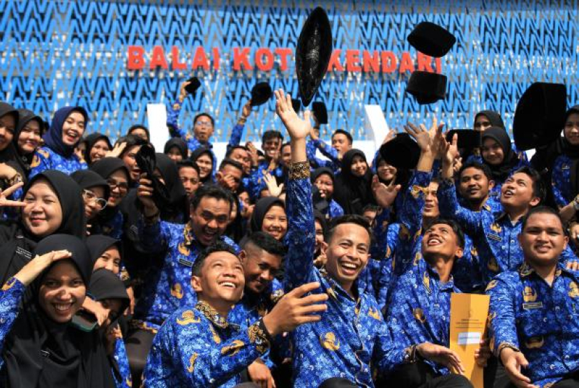 Sejumlah pegawai melempar peci usai disumpah menjadi PNS di Pemerintah Kota Kendari, Kendari, Sulawesi Tenggara, Senin (17/10/2022). Foto: ANTARA/Jojon