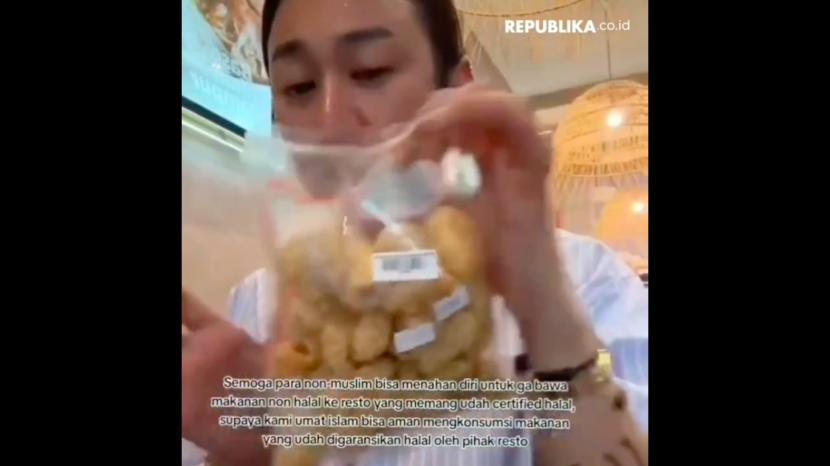 Selebgram Jovi Adighuna makan kerupuk babi di restoran Bakso A Fung.