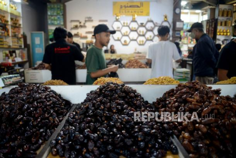 Pedagang melayani pembeli buah kurma di toko Elshanum, Tanah Abang, Jakarta, Ahad (26/3/2023). Foto: Republika/Prayogi