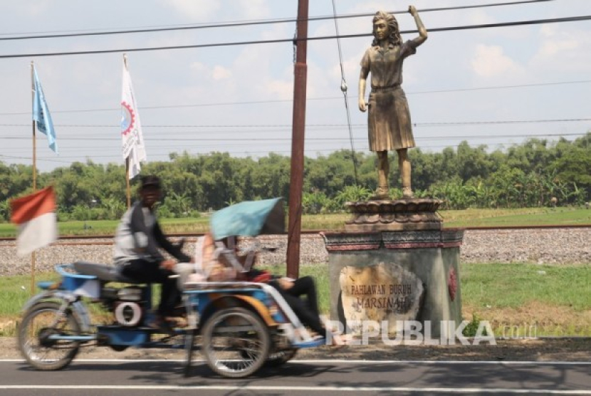 Warga melintas di depan patung Marsinah di Desa Nglundo, Nganjuk, Jawa Timur, Rabu (1/5/2019). On This Day: 8 Mei 1993, Jasad Marsinah Ditemukan Setelah Dibunuh dengan Keji. Foto: Antara/Prasetia Fauzani