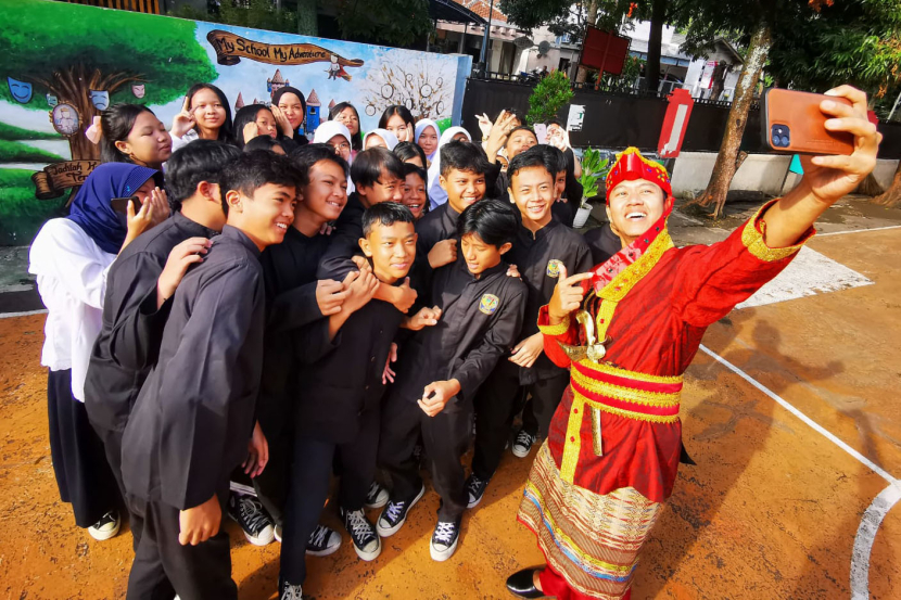 Staf pengajar berswafoto dengan siswa-siswi yang juga berpakaian tradisional usai mengikuti Upacara peringatan Hari Pendidikan Nasional di Lapang sekolah SMPN 7 Bandung, Kamis (2/5/2024).