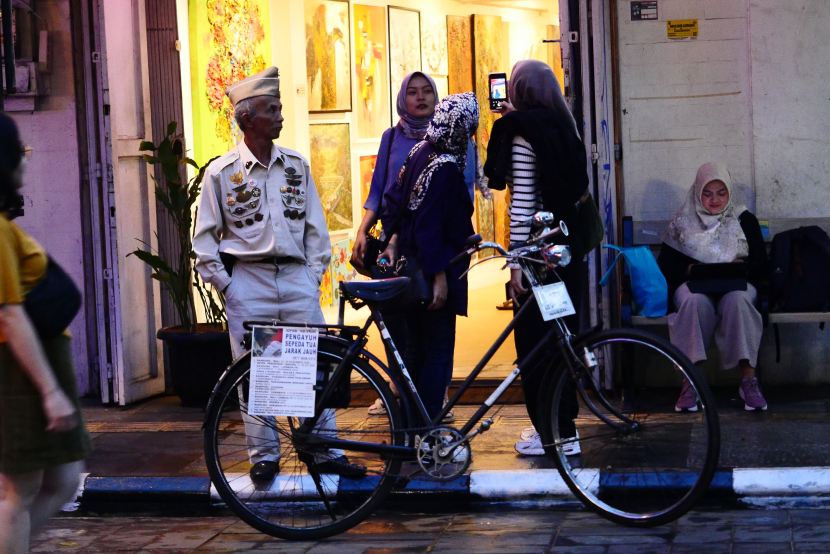Cosplayer bersepeda ontel berdiri di depan galeri seni di sela pelaksanaan Braga Bebas Kendaraan (Braga Beken) di Jalan Braga Panjang, Sabtu (4/5/2024). (Foto Yogi Ardhi/Republika Network)
