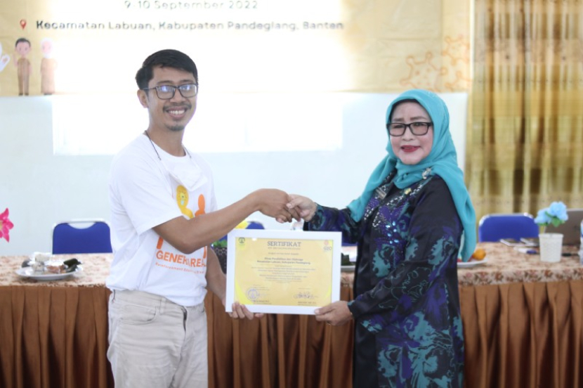 Penyerahan plakat kepada perwakilan Kormin Disdikpora Kec. Labuan, Pandeglang, Hj. Tatu Yati, S.S., M. (Dok. Panitia) 