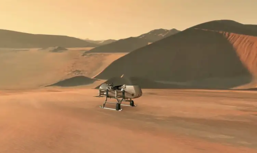 Ilustrasi ini menunjukkan wahana rotorcraft-lander Dragonfly milik NASA saat mendekati sebuah lokasi di bulan eksotis Saturnus, Titan. Memanfaatkan atmosfer padat Titan dan gravitasi rendah, Dragonfly akan menjelajahi belasan lokasi di seluruh dunia es, mengambil sampel dan mengukur komposisi bahan permukaan organik Titan untuk mengkarakterisasi kelayakhunian Titan dan menyelidiki perkembangan kimia prebiotik. Gambar: NASA/JHU-APL