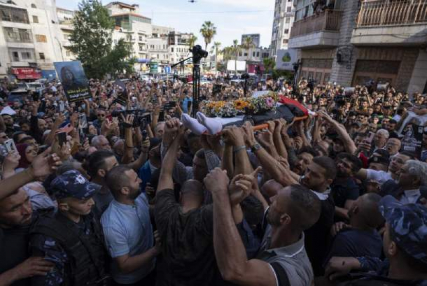 Warga Palestina mengarak jenazah jurnalis Aljazirah Shireen Abu Akleh sembari memberikan hormat di Ramallah, Tepi Barat, Rabu (11/5/2022). (AP Photo/Nasser Nasser)  