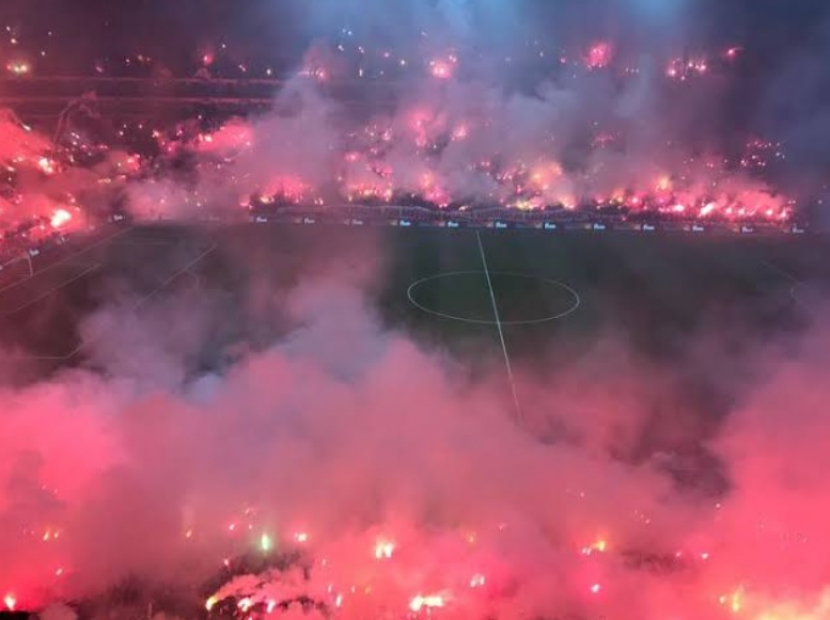 Fans Galatasaray menyalakan kembang api dalam sebuah pertandingan di Stadion Nef. (Twitter/@GalaFans)