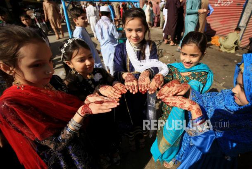 Anak-anak Muslim Pakistan menunjukkan henna mereka saat perayaan Idul Fitri di Peshawar, Pakistan, Sabtu (22/4/2023). Pawai Obor, Makanan Khas Hingga Henna: Inilah Tradisi Idul Adha di Seluruh Dunia. Foto: EPA-EFE/ARSHAD ARBAB