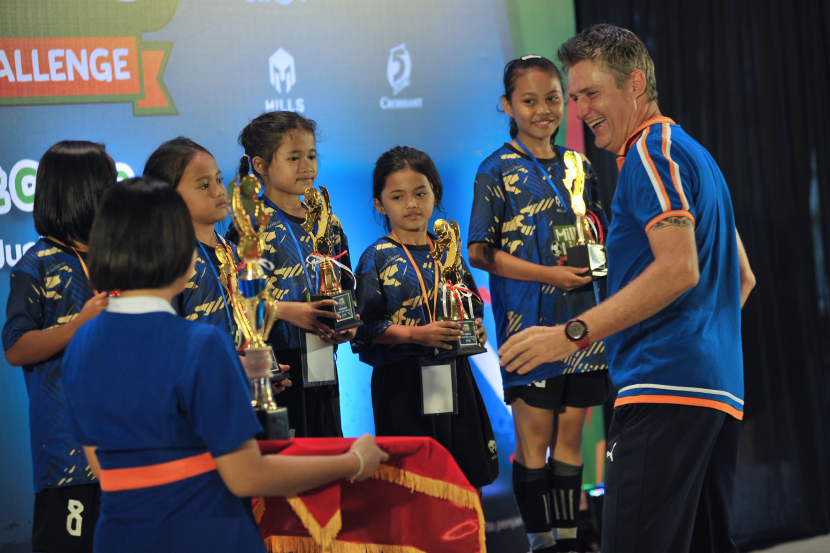 Kepala Pelatih MilkLife Soccer Challenge, Timo Scheunemann memberikan piala kepada pemenang pada acara MilkLife Soccer Challenge-Bandung Series 1 2024 di Progressif Sport Center Bandung, Jumat (21/6/2024).