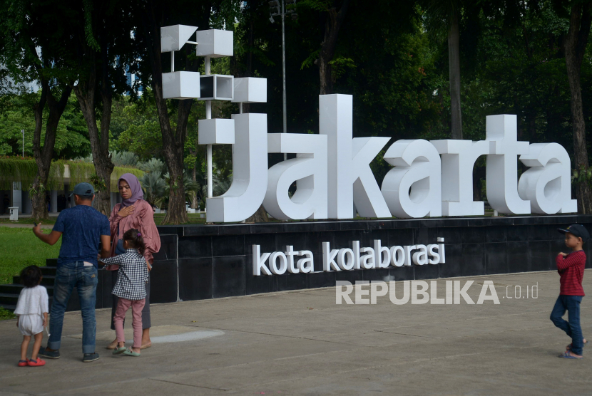 Warga melintas di dekat instlasi logo PlusJakarta dengan slogan Kota Kolaborasi di Taman Lapangan Banteng, Jakarta, Senin (12/12/2022). Foto: Republika/Prayogi