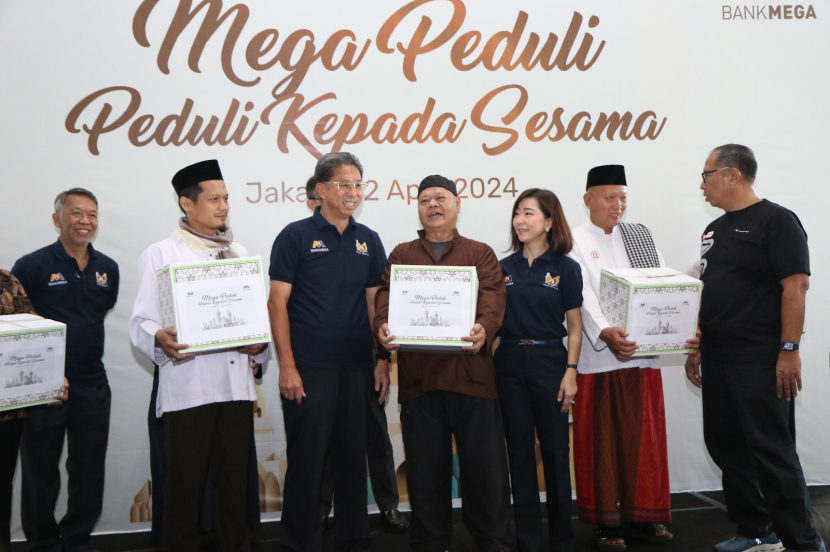 Direktur Utama Bank Mega Kostaman Thayib didampingi oleh Wakil Direktur Utama Bank Mega Diza Larentie menyerahkan bantuan berupa paket sembako kepada warga di sekitar area kantor cabang Bank Mega di Jakarta, Selasa (2/4/2024). 