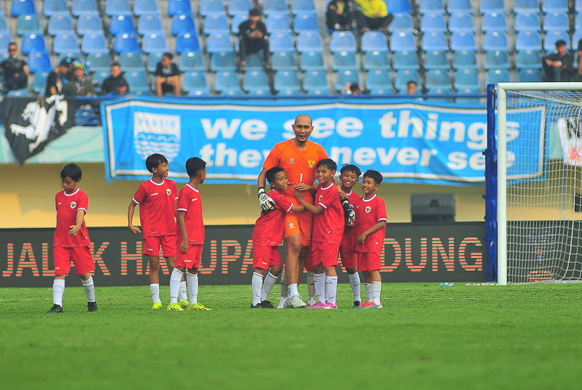 Mantan kiper Persib Bandung Markus Horison dikerubuti puluhan siswa SSB sehingga tidak bisa bergerak bebas pada laga funsoccer jelang pembukaan Turnamen Piala Presiden 2024 di Stadion Si Jalak Harupat, Kabupaten Bandung, Jumat (19/7/2024).  (FOTO: YOGI ARDHI/REPUBLIKA NETWORK) Nikon D3, Nikkor 300/2.8 ED MF.