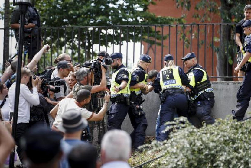 Polisi turun tangan di tempat kejadian di mana seorang pria membakar Alquran di luar masjid di Stockholm, Swedia, tepat saat Idul Adha, Rabu (28/6/2023). Alquran Dibakar Lagi di Swedia Saat Idul Adha, Banjir Kemarahan dari Dunia Muslim. Foto: EPA-EFE/STEFAN JERREVANG