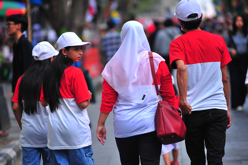 Sebuah keluarga kompak mengenakan pakaian bernuansa merah putih menikmati suasana sore di Jalan Braga Bandung, Sabtu (17/8/2024). (Foto Yogi Ardhi/Republika Network) (Nikon D3, Nikkor 80-200/2.8 Gen III).