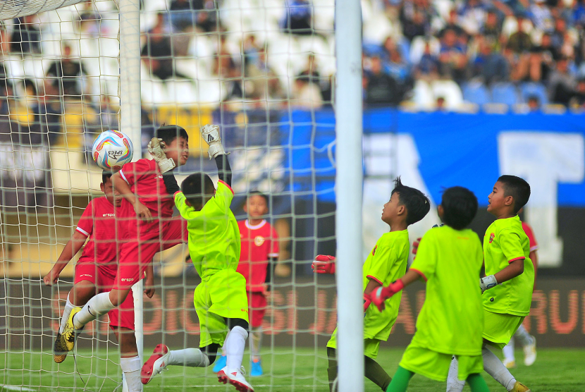 Lima kiper tim siswa SSB gagal menahan bola lambung Atep Rizal pada laga funsoccer jelang pembukaan Turnamen Piala Presiden 2024 di Stadion Si Jalak Harupat, Kabupaten Bandung, Jumat (19/7/2024).  (FOTO: YOGI ARDHI/REPUBLIKA NETWORK) Nikon D3, Nikkor 300/2.8 ED MF.