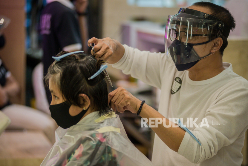 Karyawan melayani pelanggan yang melakukan perawatan rambut di Alfons Salon, Jakarta, Senin (15/6/2021). Republika/Thoudy Badai