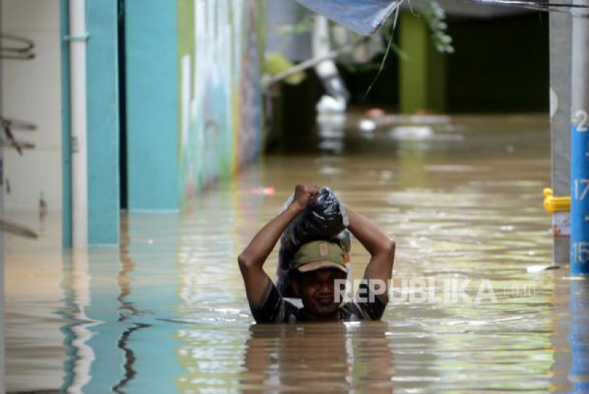 Seorang warga melintasi banjir yang merendam kawasan Kebon Pala, Kampung Melayu, Jatinegara, Jakarta Timur, Senin (27/2/2023). Foto: Republika/Prayogi