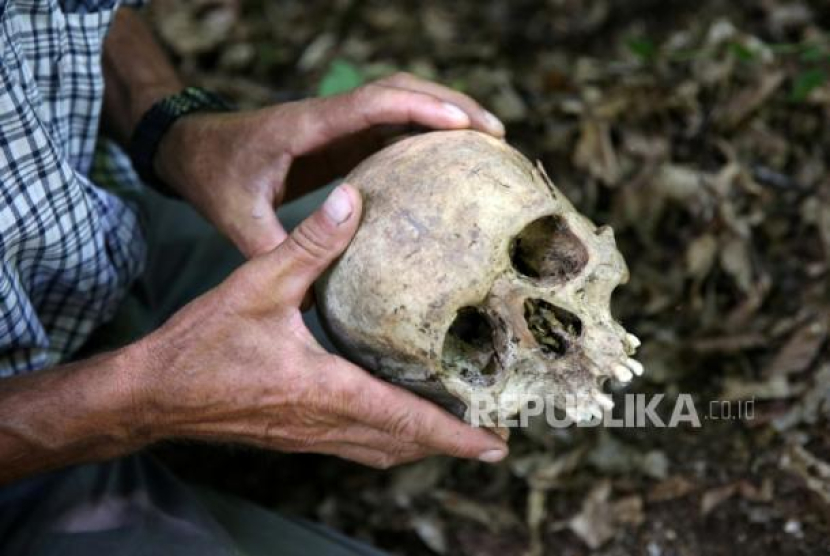 Korban genosida Srebrenica Ramiz Nukic melihat tengkorak yang ia temukan di hutan dekat Konjevic Polje, Bosnia dan Herzegovina, 6 Juli 2020. Nukic berjanji pada dirinya akan mencari sisa-sisa orang hilang korban pembantaian Muslim di Srebrenica hingga akhir. Foto: REUTERS/Dado Ruvic