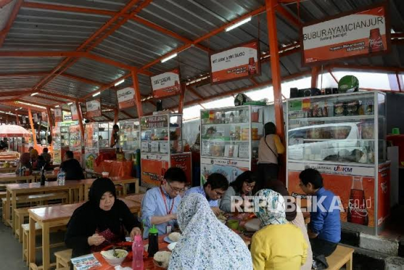 Keterangan: sekelompok orang sedang menyantap makanan di kantin