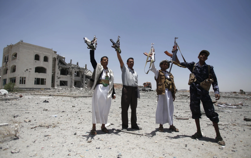 Pejuang Syiah, yang dikenal sebagai Houthi, mengangkat senjata sambil meneriakkan slogan-slogan di kediaman komandan militer kelompok militan Houthi, yang dihancurkan oleh serangan udara pimpinan Saudi di Sanaa, Yaman, Selasa, 28 April 2015. (AP Foto/Hani Mohammed, File)